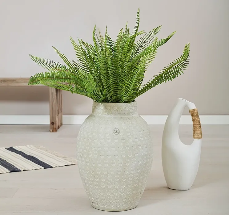 Kunstig bregne plante på stilk af plast uv beskyttet vist i en hvid terracotta vase i miljø