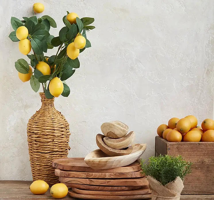 Citron gren kunstig af plast med gule citroner i køkken miljø med træfade