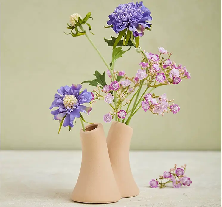 Skabiosa kunstig blomst af plast i blå vist i lille vase med to huller og en kunstig brudeslør gren