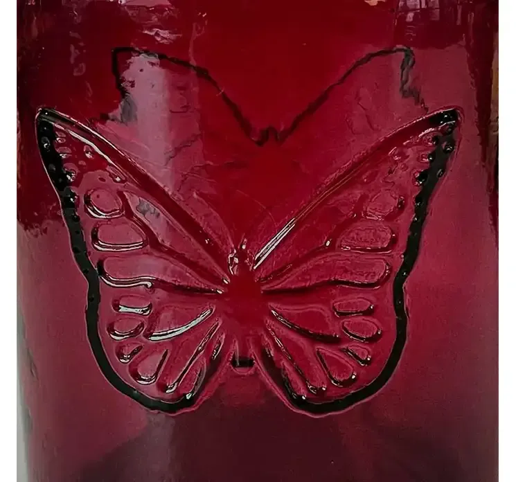 Vase af glas i mørk pink med sommerfugle motiv closeup