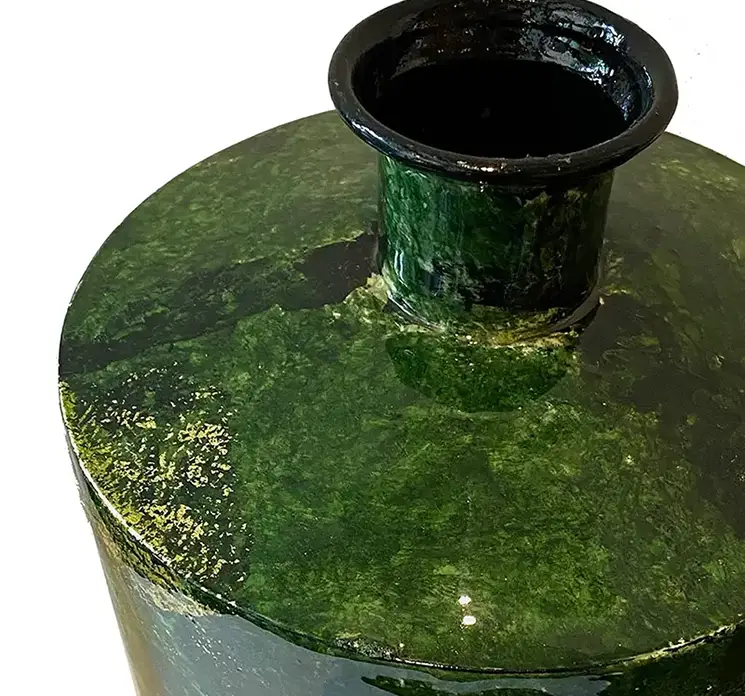 vase af metal i grøn med smal åbning i toppen closeup