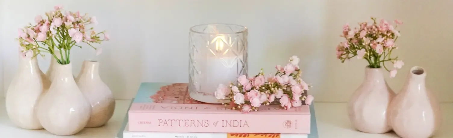 Små vaser vist på en hylde med kunstige brudeslørs buketter